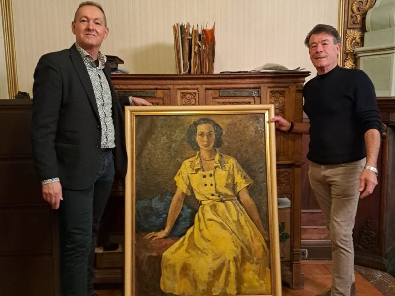 Foto van 2 mannen met een schilderij